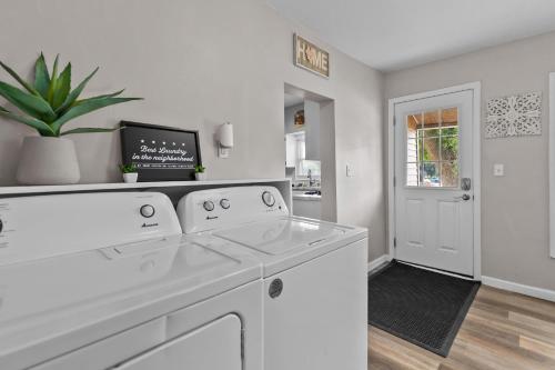 a kitchen with white appliances and a plant at Central Oshkosh Stay - Walk to Lake and Downtown in Oshkosh