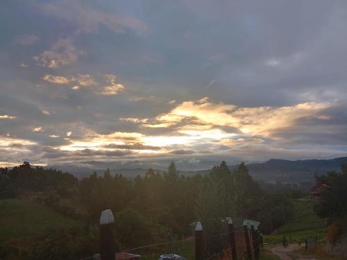 にあるCamping Nuevo Amanecerの木々の丘からの夕日の眺め