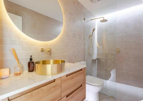 a bathroom with a gold sink and a shower at Upscale neighbourhood guest quarters in Perth
