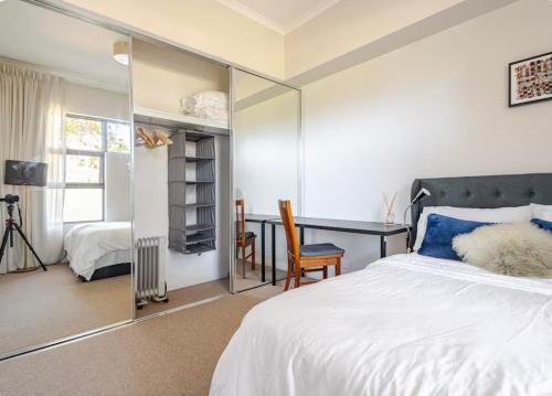 a bedroom with a bed and a desk with a mirror at Upscale neighbourhood guest quarters in Perth