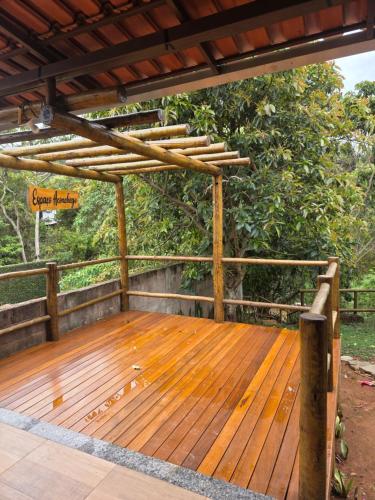 a wooden deck with a wooden pergola at Cantinho do Ipê Alto Caparaó MG in Alto Caparao