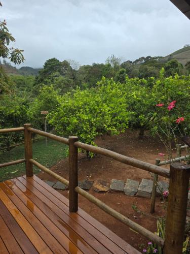 a wooden deck with a view of a garden at Cantinho do Ipê Alto Caparaó MG in Alto Caparao