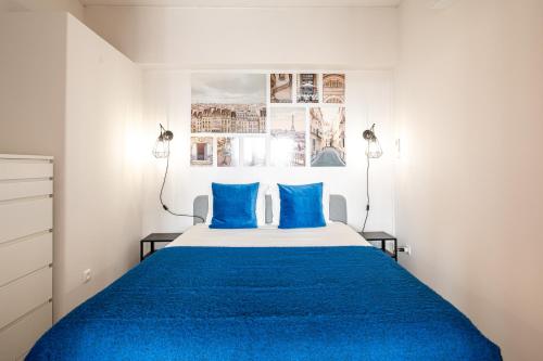 a bedroom with a blue bed with blue pillows at Amazing Sea View Apt with Pool Cascais - atjoanas in Cascais
