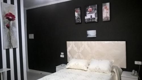 a black and white bedroom with a bed and pictures on the wall at Hotel Gines in Ginés