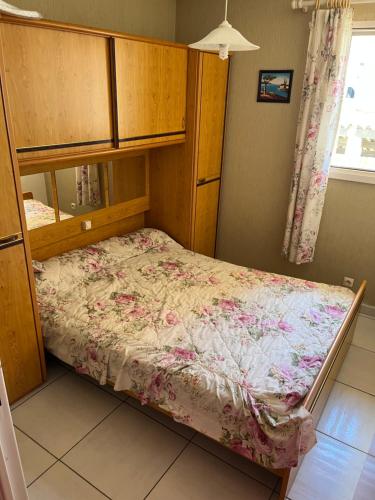 um quarto com um beliche com uma colcha floral em séjour d'exception face a la marina et plage à 100m em Sète