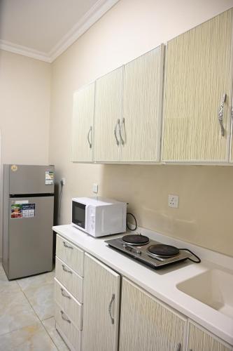 a kitchen with a microwave and a refrigerator at مثوى in Al Madinah