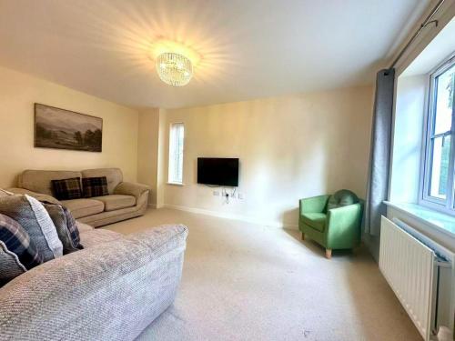a living room with a couch and a tv at Charming 3 bedroomed House in Bicester sleeps 6 in Chesterton