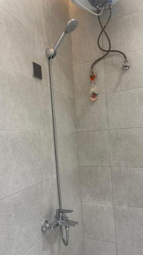 une douche avec pommeau de douche dans une salle de bain dans l'établissement Luxury apartment with outdoor seating, separate entrance and self check-in, à Khamis Mushait