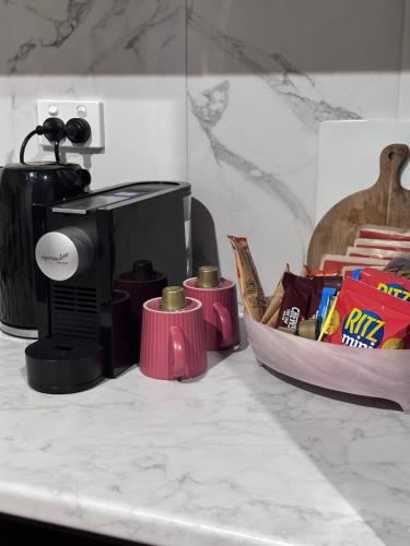 a counter with a coffee maker and a basket of food at Aurora Self Contained Studio in Brisbane