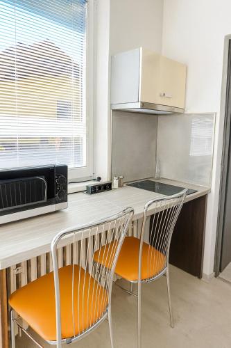 a kitchen with two chairs sitting at a counter at Apartmán 12 in Otilia