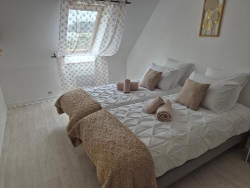 a bedroom with a bed with pillows and a window at Chez Ninie in Le Cloître-Saint-Thégonnec