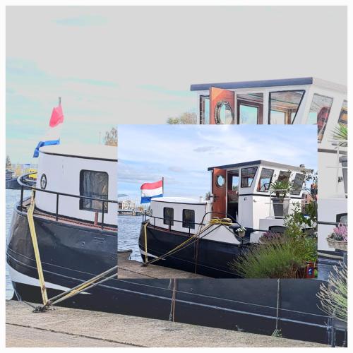 a small boat is docked at a dock at B&B Teddy "Prachtig authentiek woonschip uit 1912, 15 minuten van Amsterdam" in Wormer