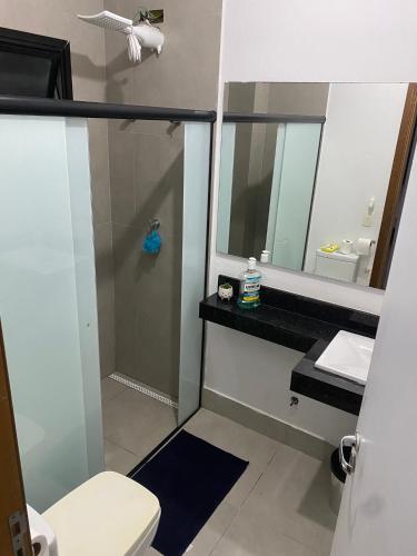une salle de bain avec un lavabo, des toilettes et un miroir dans l'établissement Lourenço House, à Barueri
