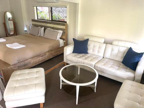a room with a bed and a couch and a table at Gin's Rainforest stay -pet friendly in Mount Tamborine
