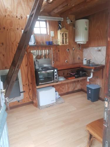 a kitchen with wooden walls and wooden flooring in a cabin at Cabaña in El Chalten