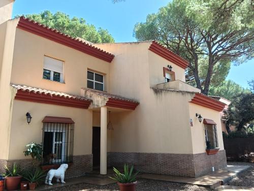 a dog stands in front of a house at WOWHOLIDAYS La Juliana de Sevilla in Bollullos de la Mitación