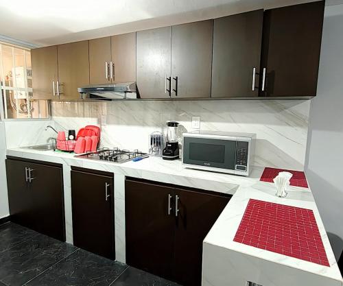 a kitchen with a stove and a microwave at El Depa de Johan - Estadio in Ciudad Madero