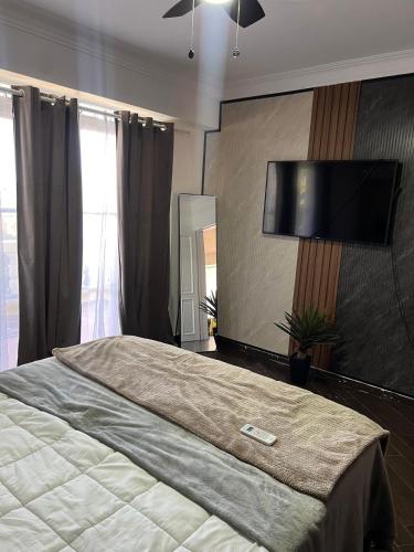 a bedroom with a large bed with a flat screen tv on the wall at Brisa de Mar in Boca Chica