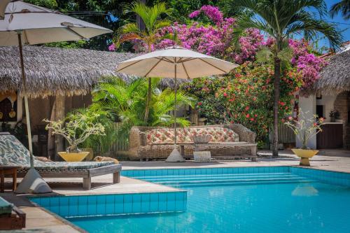 una piscina con sillas y sombrillas en un resort en Controvento Boutique Hotel, en Cumbuco