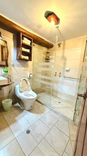 a bathroom with a toilet and a shower at Hotel Maderanegra By Huasicama in Latacunga