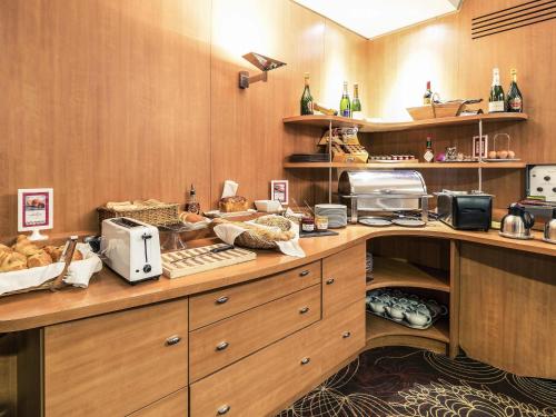 Una cocina con encimera con pan y electrodomésticos. en Mercure Albi Rives du Tarn, en Albi