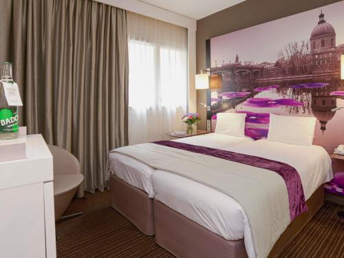 a hotel room with a large bed and a painting on the wall at Mercure Toulouse Centre Wilson Capitole in Toulouse