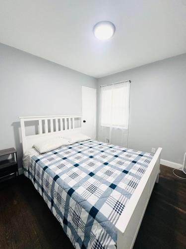 a white bedroom with a bed and a window at Spacious 4Bdrs house with parking in Hempstead