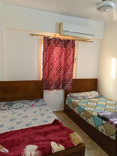 a bedroom with two beds and a window at Guest room science in Marsa Alam City