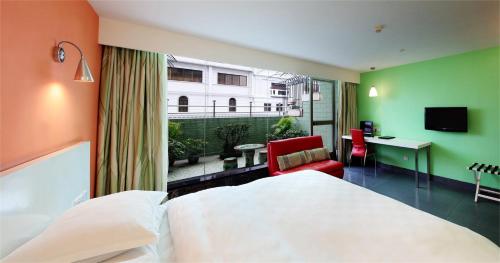 Habitación de hotel con cama, escritorio y ventana en LN Whitehouse Hotel, en Guangzhou