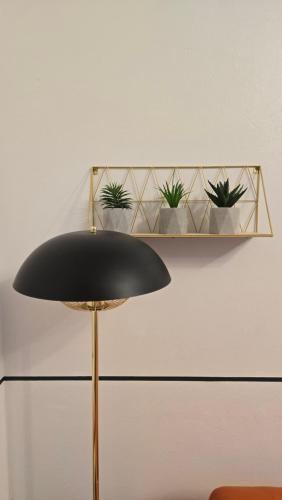 a black lamp with a shelf with potted plants at Spacious Entire House with Free Parking Perfect for Relocators Contractors and Long Term Stays in Bury