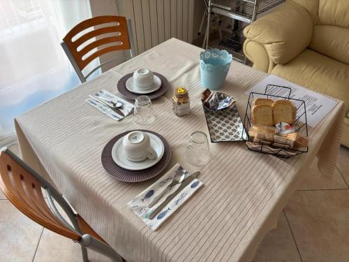 a table with a white table cloth and plates and food at B&B Altea in Pescara