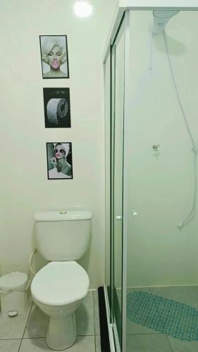 a bathroom with a toilet and a glass shower at Apto 2 quartos - Próx Shop FIP in Brusque