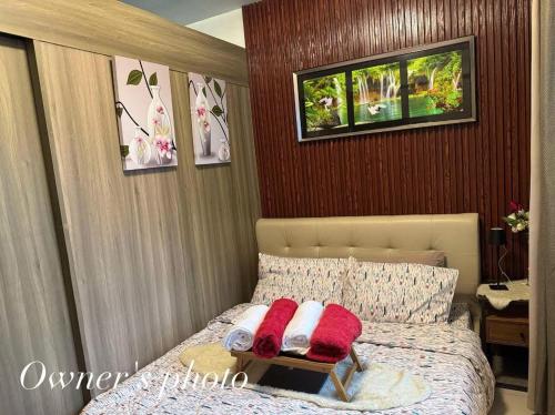 ein Schlafzimmer mit einem Bett mit zwei Kissen darauf in der Unterkunft Juvrey Studio-Unit Breeze Residences in Manila