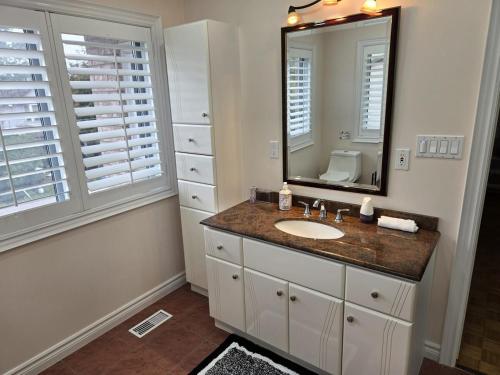 ein Badezimmer mit Waschbecken und Spiegel in der Unterkunft Charming 3 Bedroom home near the lake in Mississauga