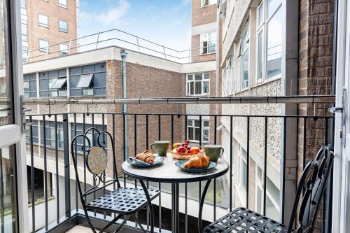 a table on a balcony with two pastries on it at Luxurious Flat at Leicester Town in Leicester