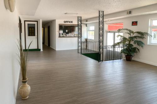 an empty room with a lobby with aoyer with plants at Economy Inn in Temple
