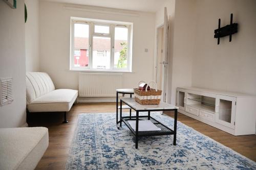 a living room with a table and a couch at Stylish Wembley Home with Hot Tub, Parking & Garden in London