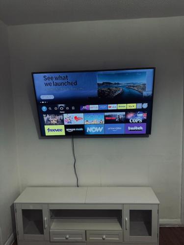 a flat screen tv hanging on a wall at Stylish Wembley Home with Hot Tub, Parking & Garden in London