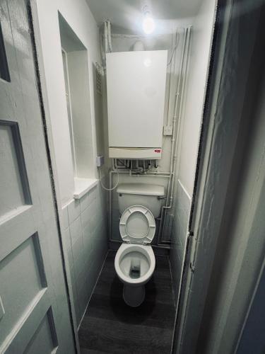 a small bathroom with a toilet in a stall at Stylish Wembley Home with Hot Tub, Parking & Garden in London