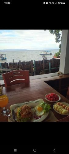 a table with a plate of food and a view of the ocean at Bunaken Blesshi Guest House in Bunaken