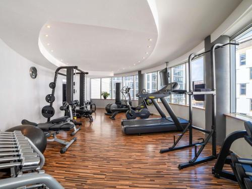 un gimnasio con cintas de correr, máquinas elípticas y bicicletas estáticas en Sofitel Luxembourg Europe, en Luxemburgo
