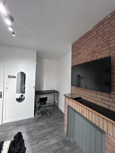 ダンケルクにあるLe Dunkerquois - Appartement moderne et tout équipéのレンガの壁にリビングルーム(薄型テレビ付)
