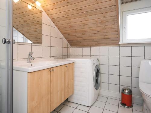 Un baño con lavadora y lavabo. en 6 person holiday home in Rømø, en Sønderby
