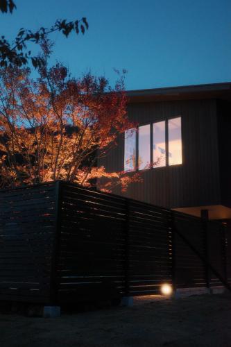 a fence in front of a house at night at 富士山望むプライベートヴィラ 900平方メートルの敷地を貸切利用 憩 ikoi Fuji サウナ 4Kシアター in Fujikawaguchiko
