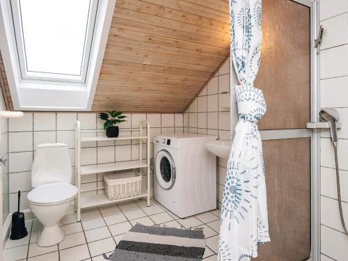 a bathroom with a washing machine and a toilet at 6 person holiday home in Rømø-By Traum in Sønderby