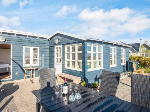 a blue house with a table and chairs at 4 person holiday home in Grenaa in Grenå