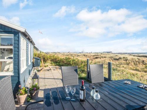 een houten tafel met wijnglazen op een patio bij 4 person holiday home in Grenaa in Grenå