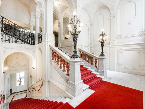 a staircase in a building with a red carpet at Nemzeti Hotel Budapest - MGallery Collection in Budapest
