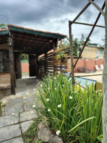 a garden with flowers in front of a building at Catavento Flats e Suítes in São Sebastião