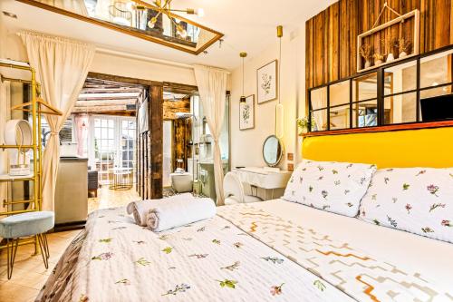 1 dormitorio con 1 cama grande y cabecero amarillo en Guest suite with hot tub and sauna, en Redbridge